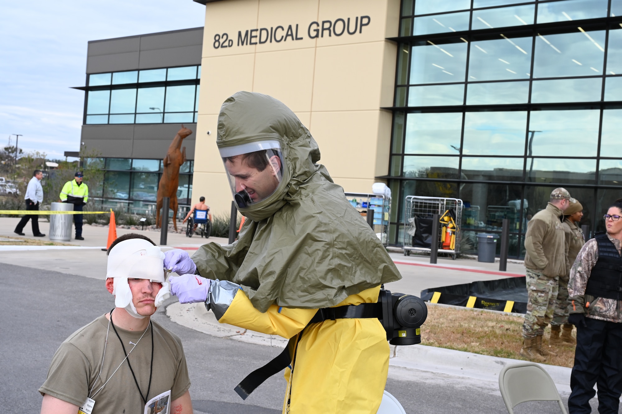 A medic wraps bandage around a test patient's head wound.