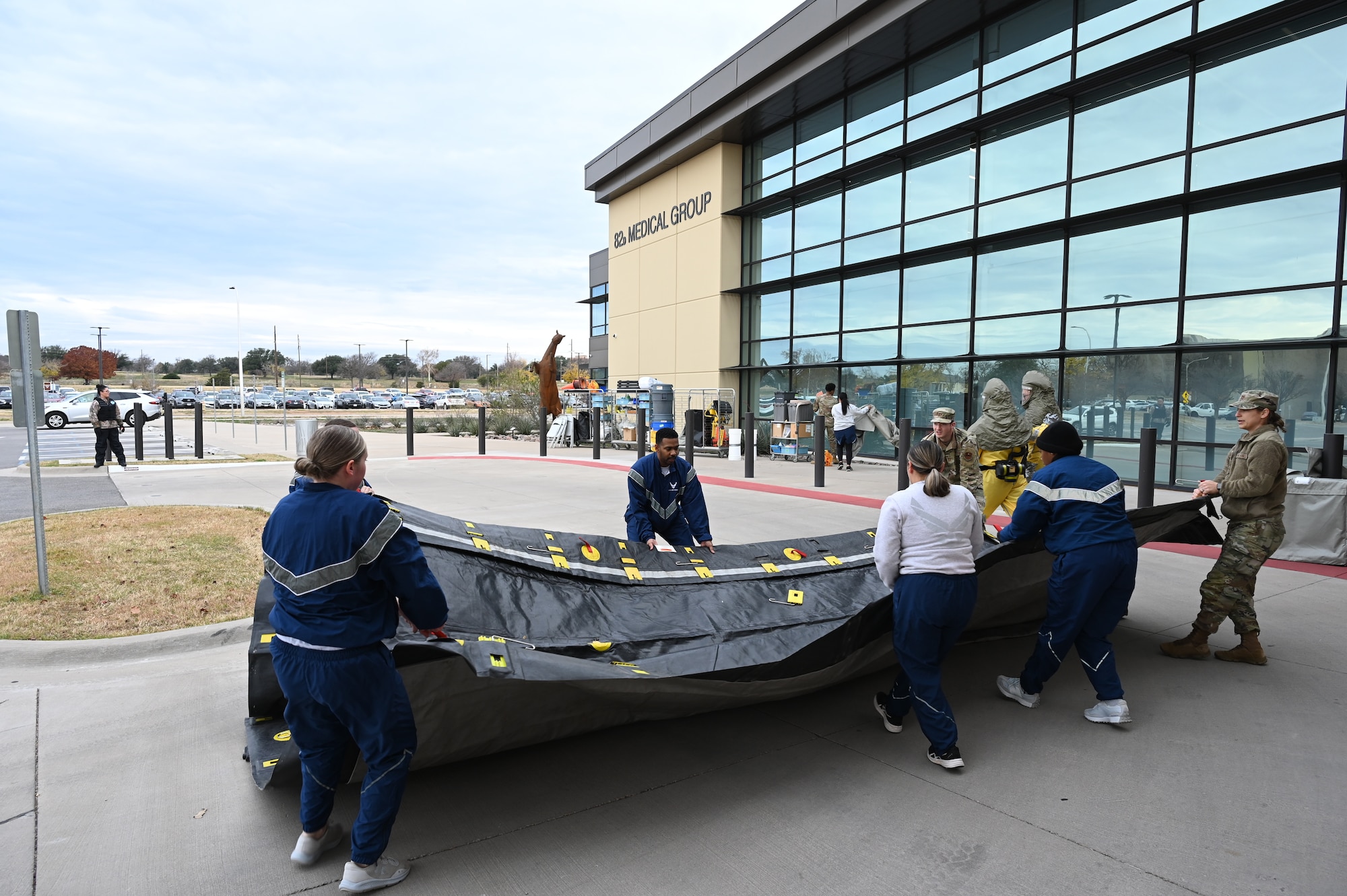The medical group staff pull apart a tent for the decontamination site.