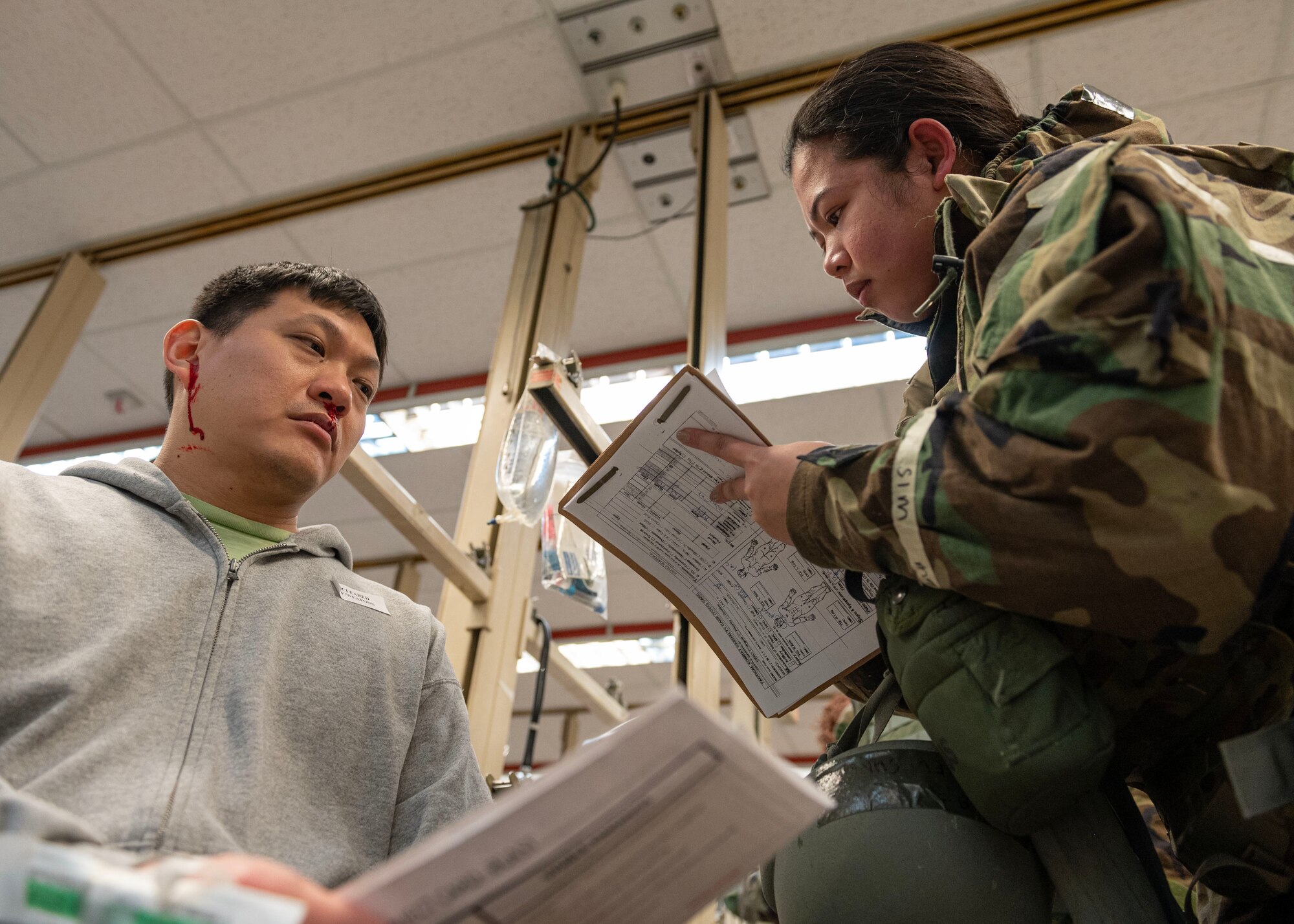 A U.S. Air Force Airman assigned to the 51st Medical Group takes notes while treating a simulated triage patient in a mass casualty training event during Beverly Midnight 24-1 at Osan Air Base, Republic of Korea, Feb. 1, 2024. Simulated patients came to the 51st MDG with a range of ailments, allowing medics to test their abilities to effectively treat the patients and practice contingency operations. BM24-1 is a routine training event that tests the military capabilities across the peninsula, allowing combined and joint training at both the operational and tactical levels. (U.S. Air Force photo by Staff Sgt. Aubree Owens)