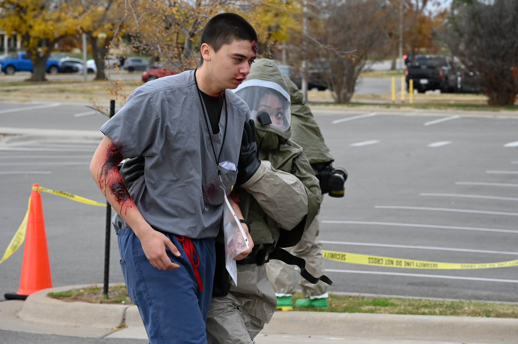 A medical group staff member walks a test patient to the decontamination site.
