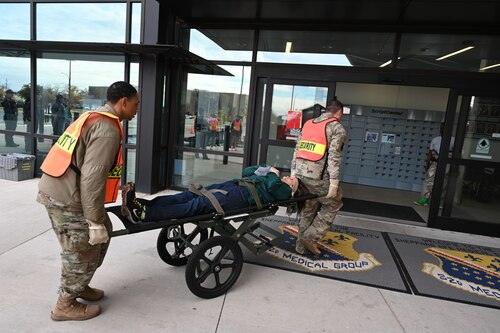 A test patient on a stretcher is rolled into the clinic.