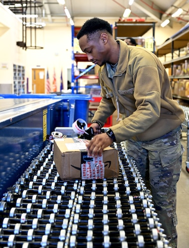 military postal clerk rewraps damaged packages