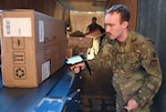 U.S. Air Force Airman 1st Class Michael Jones, 100th Force Support Squadron military postal clerk, scans incoming packages as they come off a secure truck, ensuring they are registered on the U.S. Postal Service tracking system before being made ready for customers at Royal Air Force Mildenhall, England. The Air Force Installation and Mission Support Center’s Official Mail and Postal Program is in the process of transitioning mail centers at Air Force installations to online postage services. The initiative for online postage services gives personnel the same access to mailing tools as they had before but at a fraction of a cost.  (U.S. Air Force photo by Karen Abeyasekere)