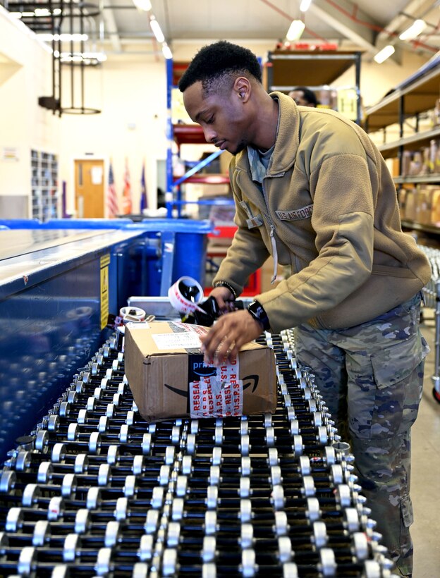 U.S. Air Force Senior Airman Zaddis Walker, 100th Force Support Squadron Post Office military postal clerk, rewraps damaged packages as they come straight off a mail truck at Royal Air Force Mildenhall, England, Feb. 2, 2024. Postal clerks rewrap and tape any mail that arrives damaged and provide a notification to customers. The post office processes and distributes mail for more than 16,000 patrons across the tri-base area. (U.S. Air Force photo by Karen Abeyasekere)