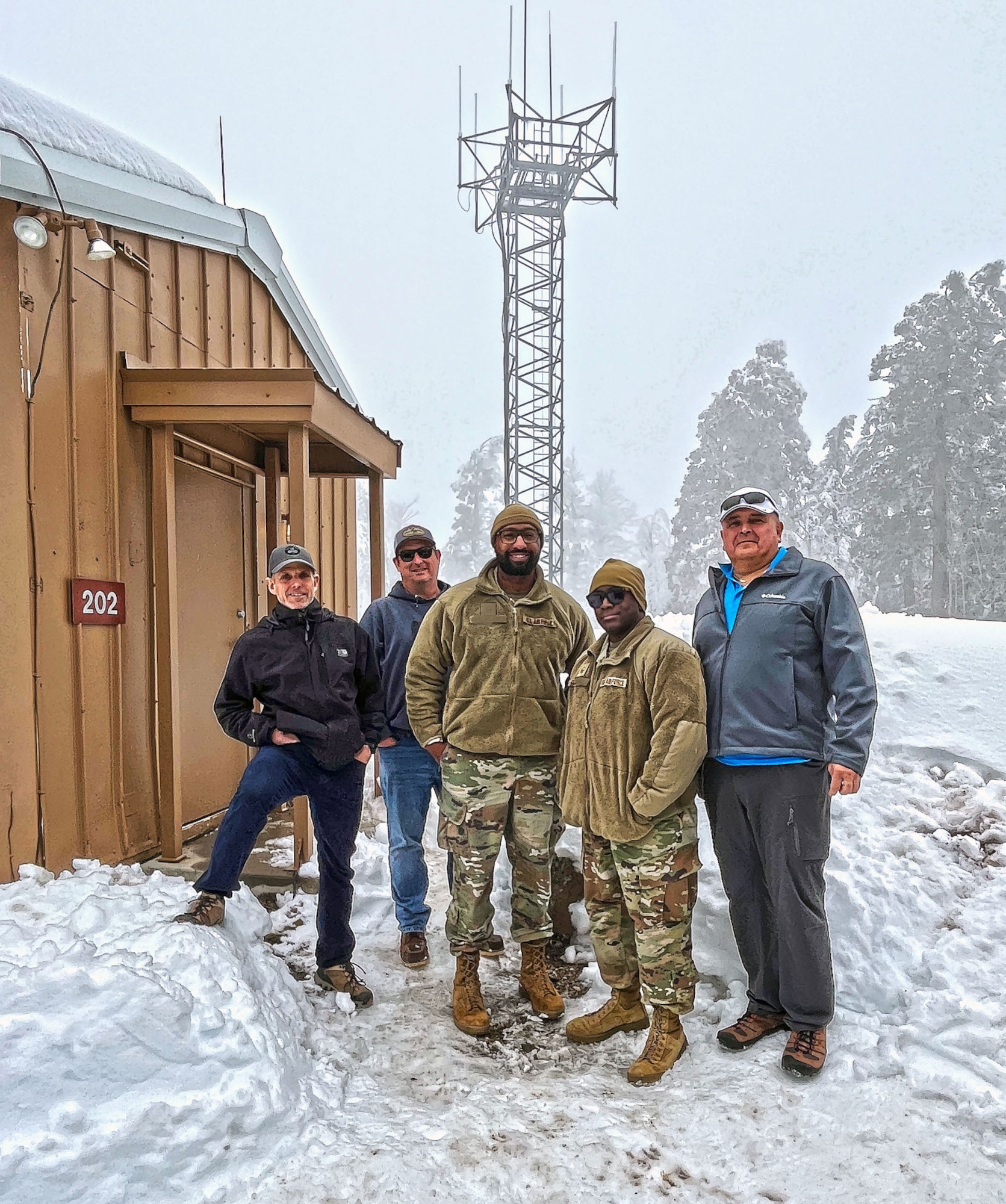 Five members of the Joint Technical Inspection team stand in front of the Mt. Lemmon Defense Program Facility in Arizona.