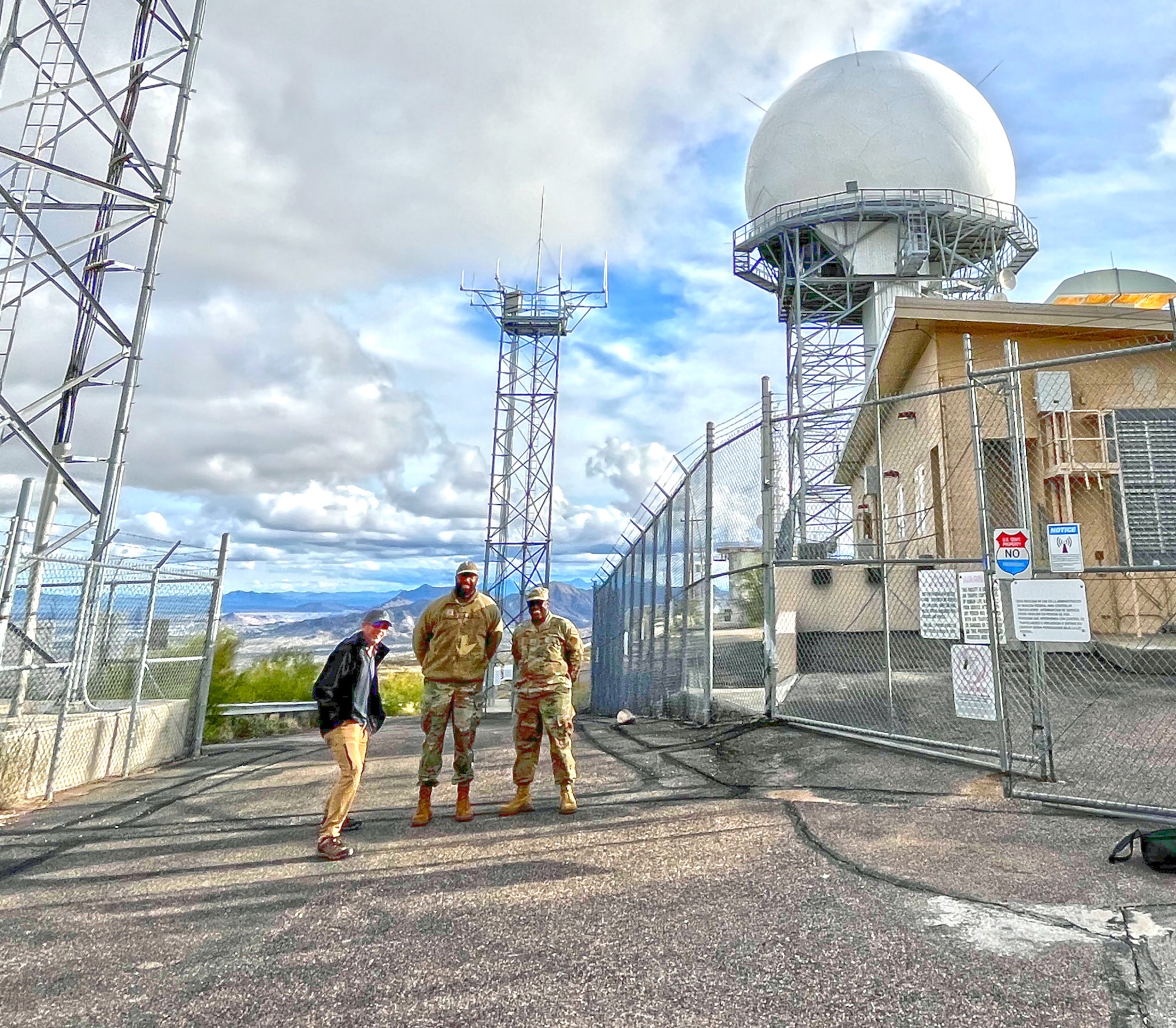 Three members of the 225th Support Squadron stand in front of Ajo Defense Program Facility radar and radio tower.