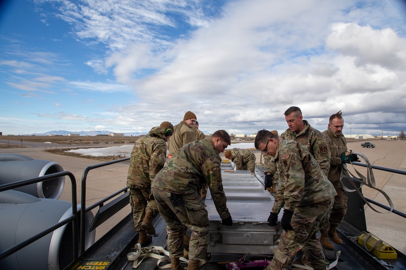 members loading missile coffins onto KC135