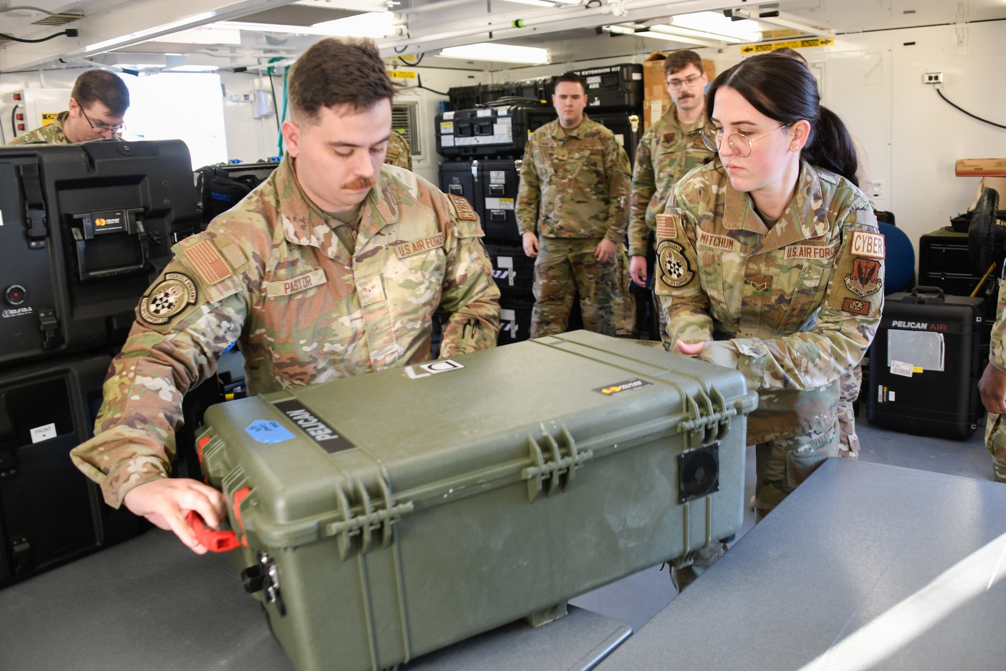 U.S. Air Force Airman 1st Class Jacob Pastor, left, and Senior Airman Carmen Mitchum, both assigned to the 752nd Operations Support Squadron, install hardware for the Tactical Operations Center – Light as Airmen assigned to the 134th Air Control Squadron observe the setup process during a training collaboration at McConnell Air Force Base, Kansas, Jan. 29, 2024. The TOC-L system is a mobile tactical-edge battle management system designed to operate across all domains from anywhere on the battlefield. (U.S. Air National Guard photo by Master Sgt. Matt McCoy)