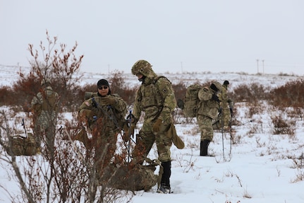 Alaska Army National Guard Spc. Jamal Murphy, left, from Kotlik, and Spc. Luke Barnes, from Palmer, both infantrymen with Bison Company, 1st Battalion, 297th Infantry Regiment, prepare to ground their gear after completing a 5-kilometer snowshoe ruck march near the Alaska Army National Guard Readiness Center in Bethel Feb. 3, 2024.