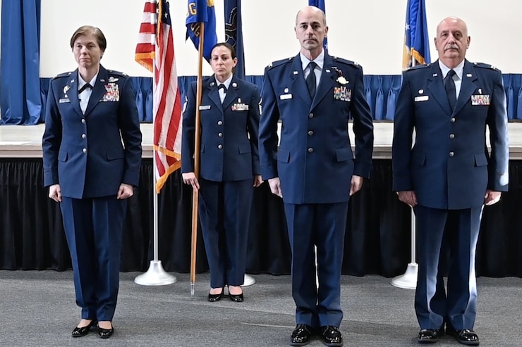 Women and men stand at attention in Air Force dress blues.