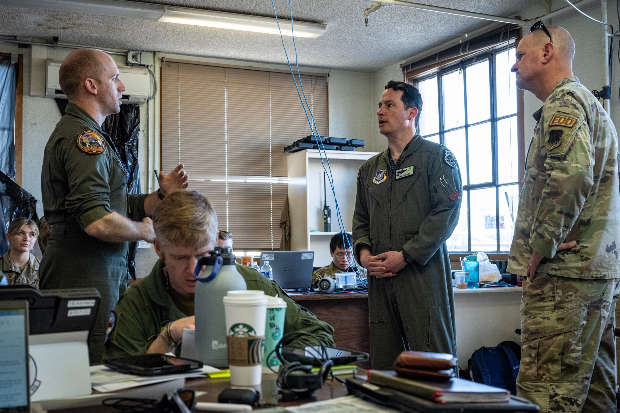 U.S. Air Force Maj. Kyle Nazarek (left), an F-22 Raptor pilot with the 525th Expeditionary Fighter Squadron, 3rd Air Expeditionary Wing, out of Joint Base Elmendorf-Richardson, Alaska, briefs U.S. Air Force Col. Kevin Jamieson (second from right), 3rd AEW commander, and U.S. Air Force Col. Joshua Demotts (right), 99th Air Base Wing commander, in the tactical operations center during Exercise Bamboo Eagle 24-1 at spoke Naval Air Station North Island, California, Jan. 31, 2024.