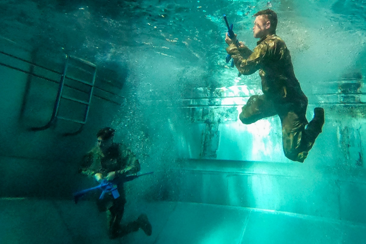 Army Sgts. Kurt Bramel and Aaron Craddock participate in a combat water survival test during the 2024 78th Troop Command Best Warrior Competition at Fort Stewart, Ga., Feb. 6, 2024.
