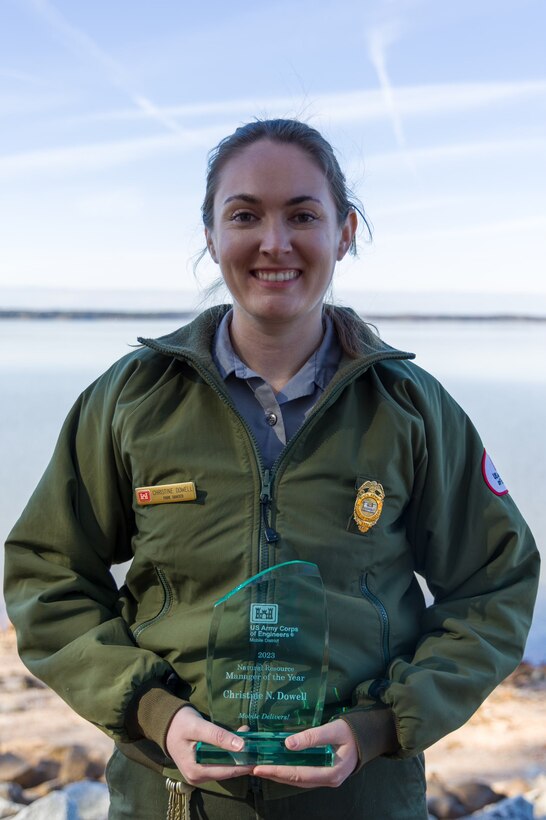 U.S. Army Corps of Engineers West Point Park Ranger Christine Dowell holds her Mobile District NRM Employee of the Year Award on the shoreline of the lake Jan. 18, 2024. (U.S. Army photo by Travis England)