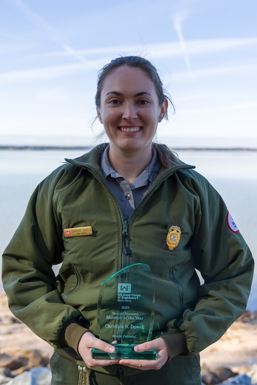 U.S. Army Corps of Engineers West Point Park Ranger Christine Dowell holds her Mobile District NRM Employee of the Year Award on the shoreline of the lake Jan. 18, 2024. (U.S. Army photo by Travis England)