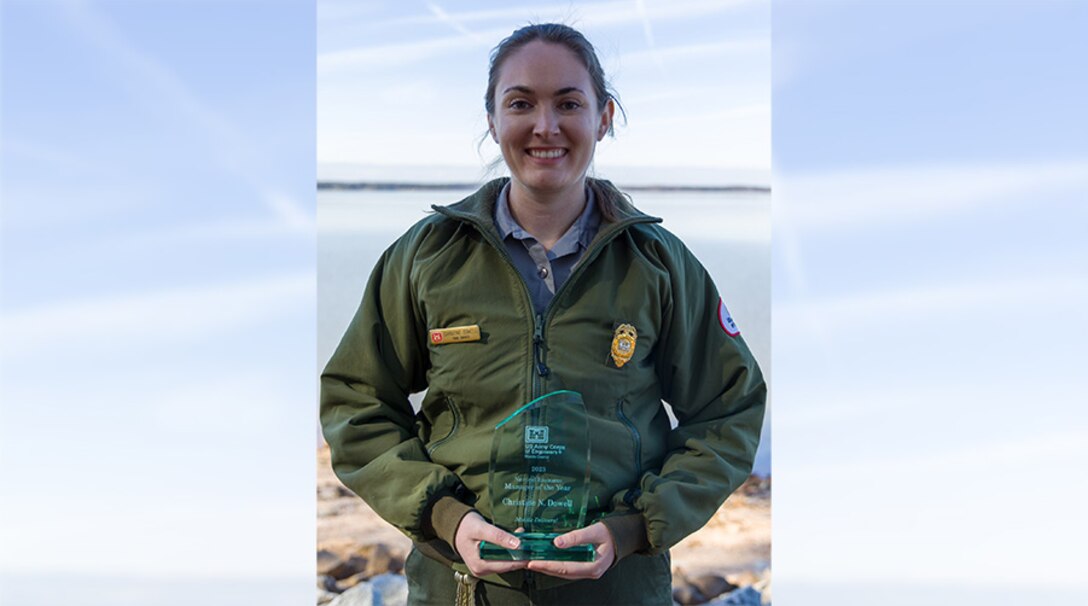U.S. Army Corps of Engineers West Point Park Ranger Christine Dowell holds her Mobile District NRM Employee of the Year Award on the shoreline of the lake Jan. 18, 2024. (U.S. Army photo by Travis England)