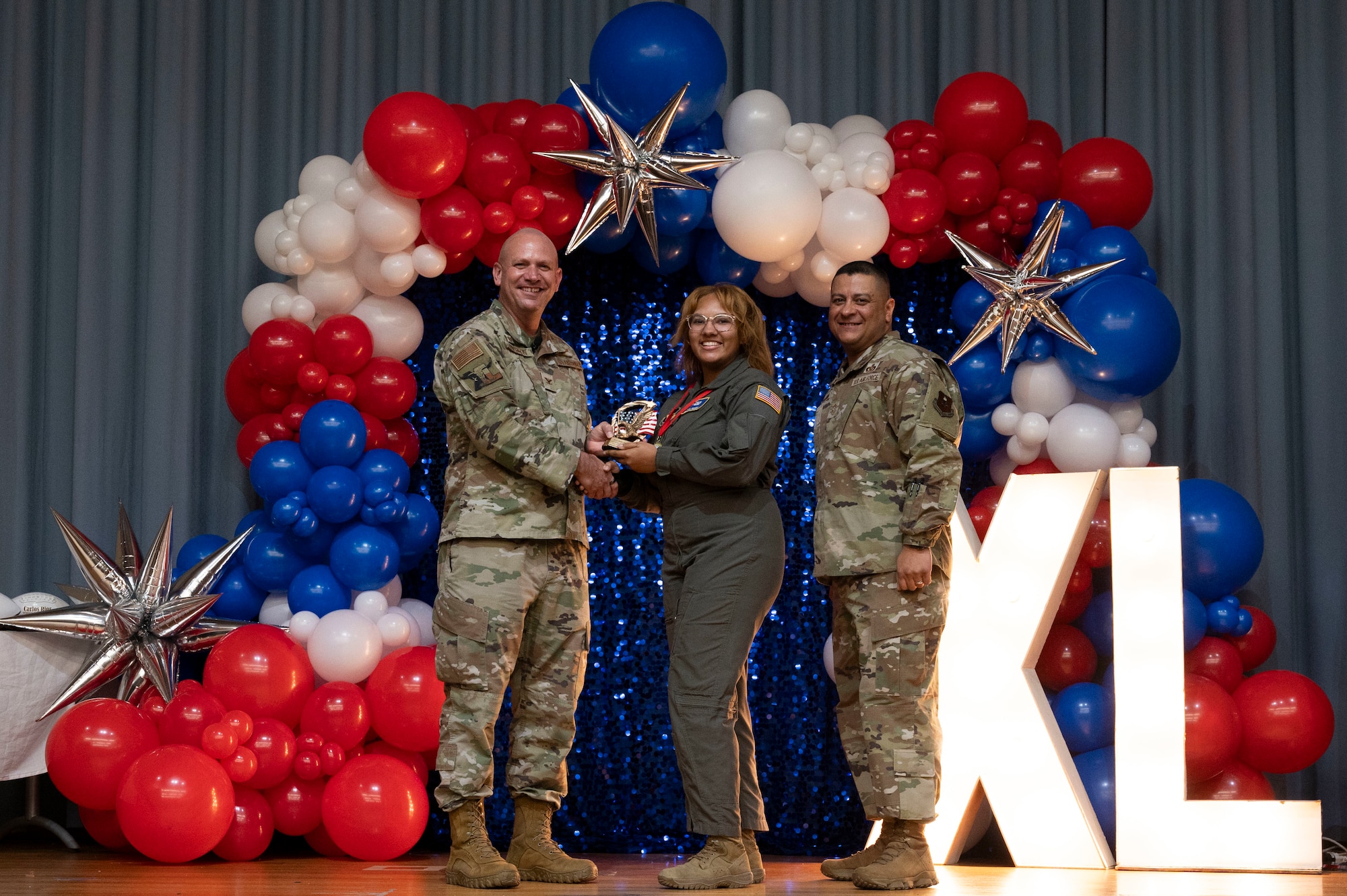 U.S. Air Force Col. Kevin Davidson, 47th Flying Training Wing (FTW) commander, and Chief Master Sgt. Lester Largaespada, 47th FTW command chief, present Senior Airman Jada Peters, 47th Operations Group, an award during the 2023 47th FTW Annual Awards Ceremony at Laughlin Air Force Base, Texas, Feb. 2, 2024. The annual awards recognized the top performers throughout the 47th Flying Training Wing during fiscal year 2023. (U.S. Air Force photo by Senior Airman Kailee Reynolds)