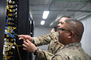 Maryland Air National Guard Staff Sgt. Edgardo Acosta, a cyber networks systems operations specialist assigned to the 175th Communications Squadron, performs cable management on a patch panel alongside airmen from the 156th Communications Flight at Muniz Air National Guard Base, Puerto Rico on July 25, 2023. The maintenance was done as part of annual training for the 175th Communications Squadron.