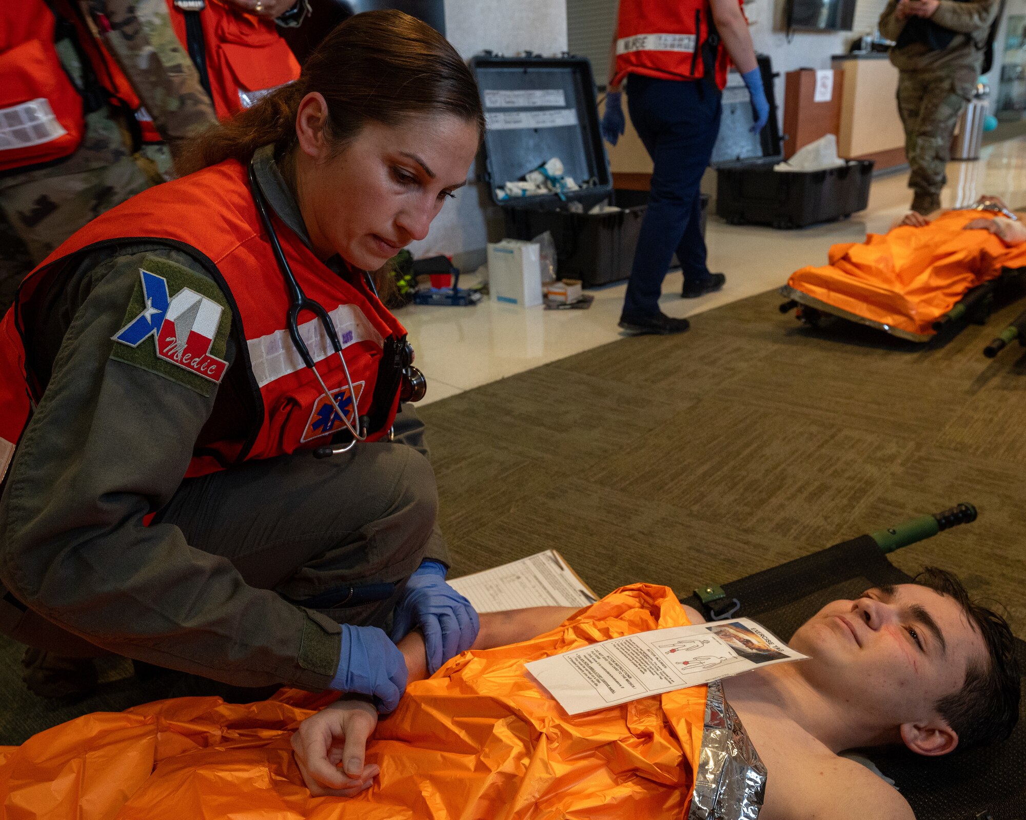 U.S. Air Force Lt. Col. Elena Arushanyan, 47th Operational Medical Readiness Squadron commander, inspects the simulated injuries of an Airman during exercise Ready Eagle II at Laughlin Air Force Base, Texas, Jan. 31, 2024. Exercise Ready Eagle II allowed Airmen to sharpen their response procedures, patient care skills, and increase service member survivability. While patients are waiting to be transported to higher-level care, they are constantly monitored for any changes in their health. (U.S. Air Force photo by Staff Sgt. Nicholas Larsen)
