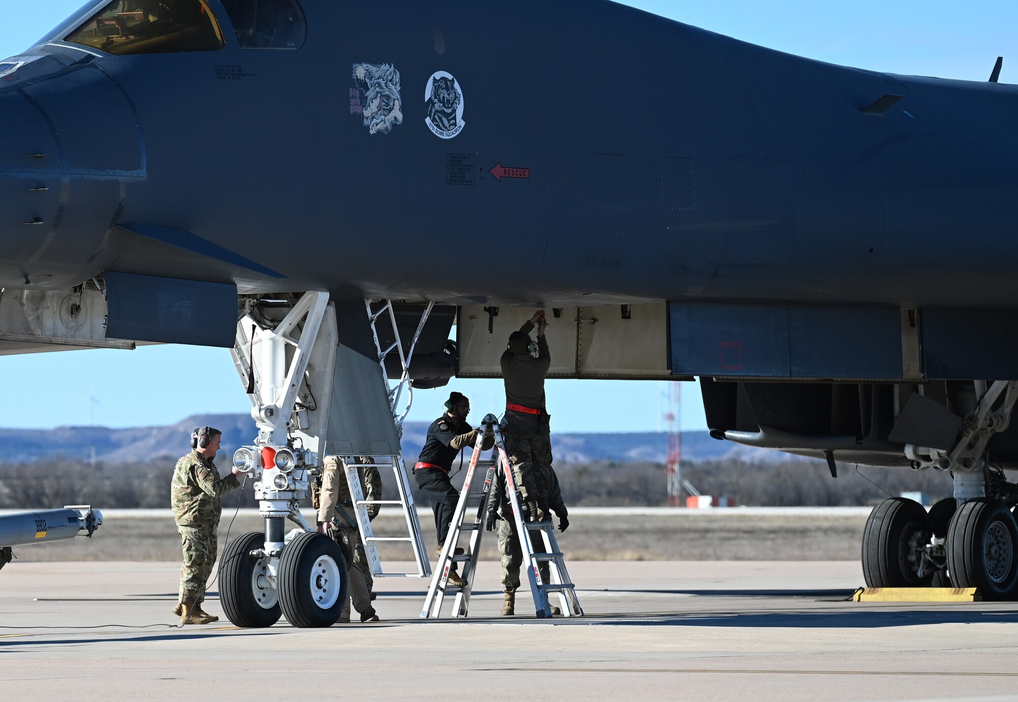 Airmen from the 28th Maintenance Group, Ellsworth Air Force Base, South Dakota, perform postflight checks on an Ellsworth AFB B-1B Lancer while 7th Bomb Wing leadership greet crewmembers on the flightline at Dyess AFB, Texas, Feb. 3, 2024. (U.S. Air Force photo by Staff Sgt. Holly Cook)