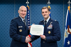 Air Force Chief of Staff Gen. David W. Allvin poses with Maj. Brady Augustin after presenting him the 2022 Koren Kolligian, Jr. Trophy during a ceremony at the Pentagon, Arlington, Va., Feb. 7, 2024.