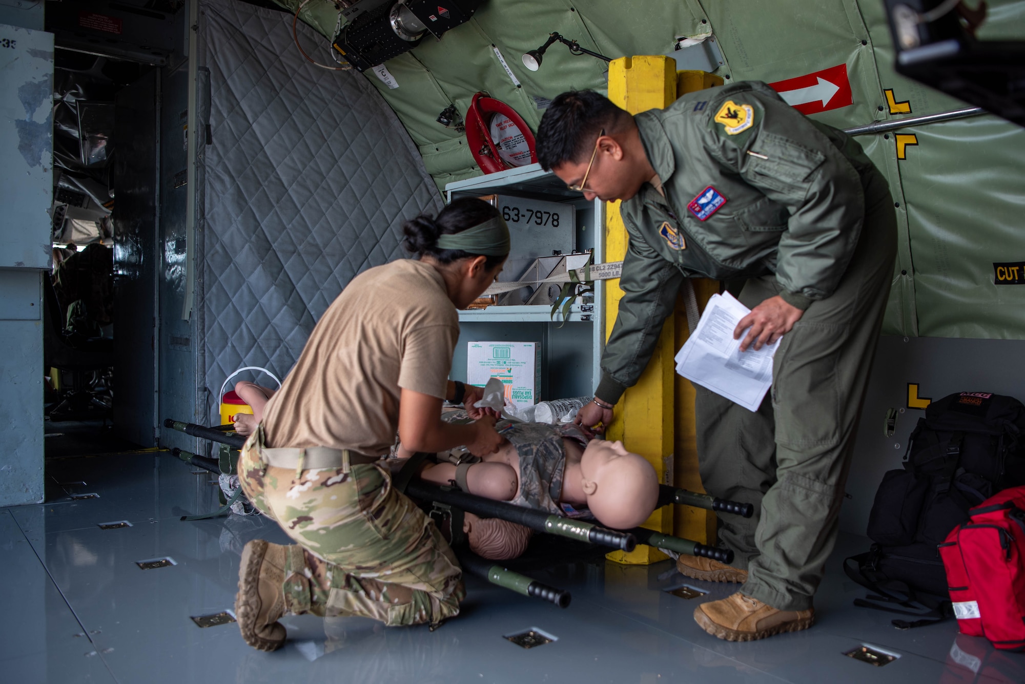 medical airmen help a manikin on a strechter