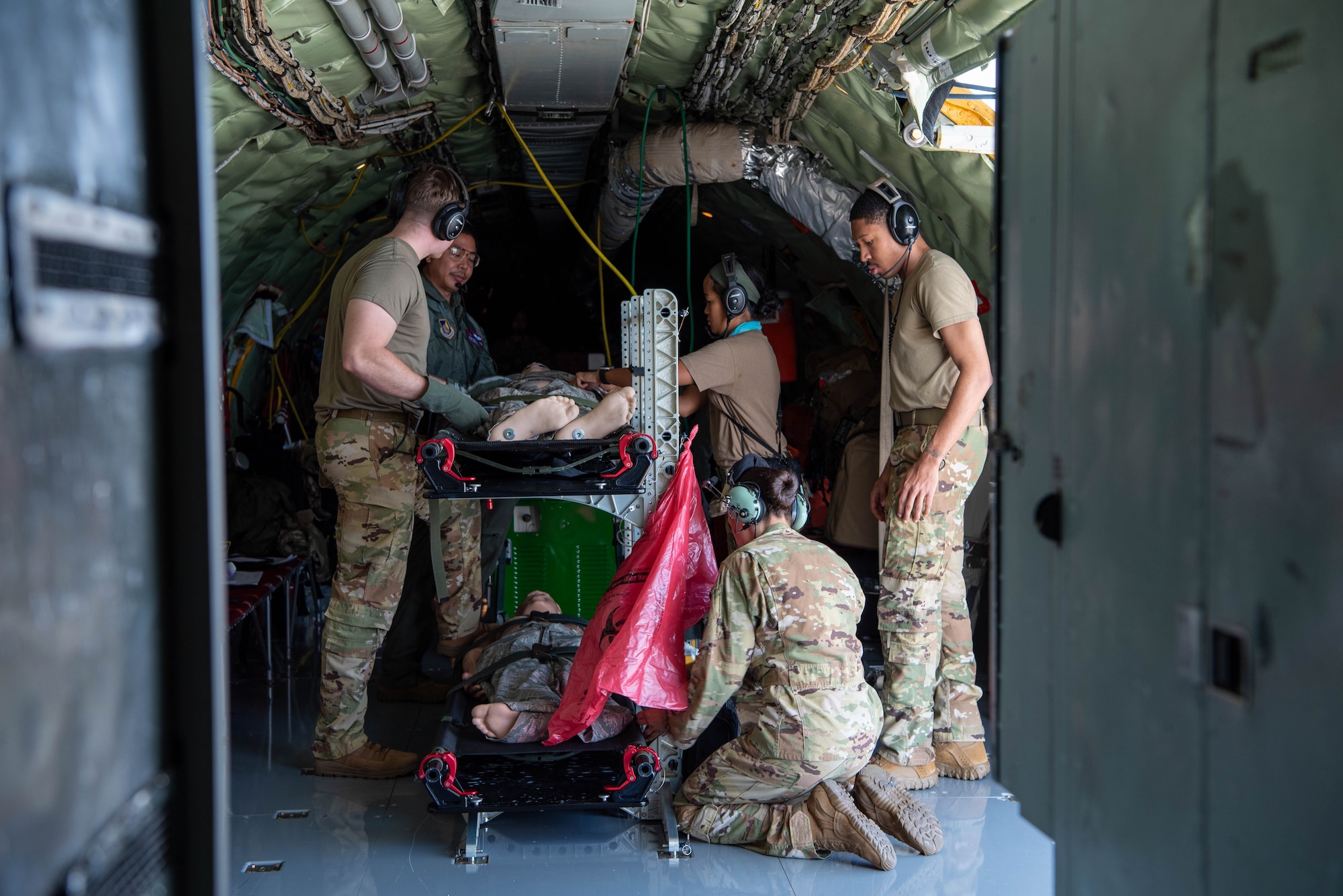 Airmen stand around two manikins preparing it for takeoff