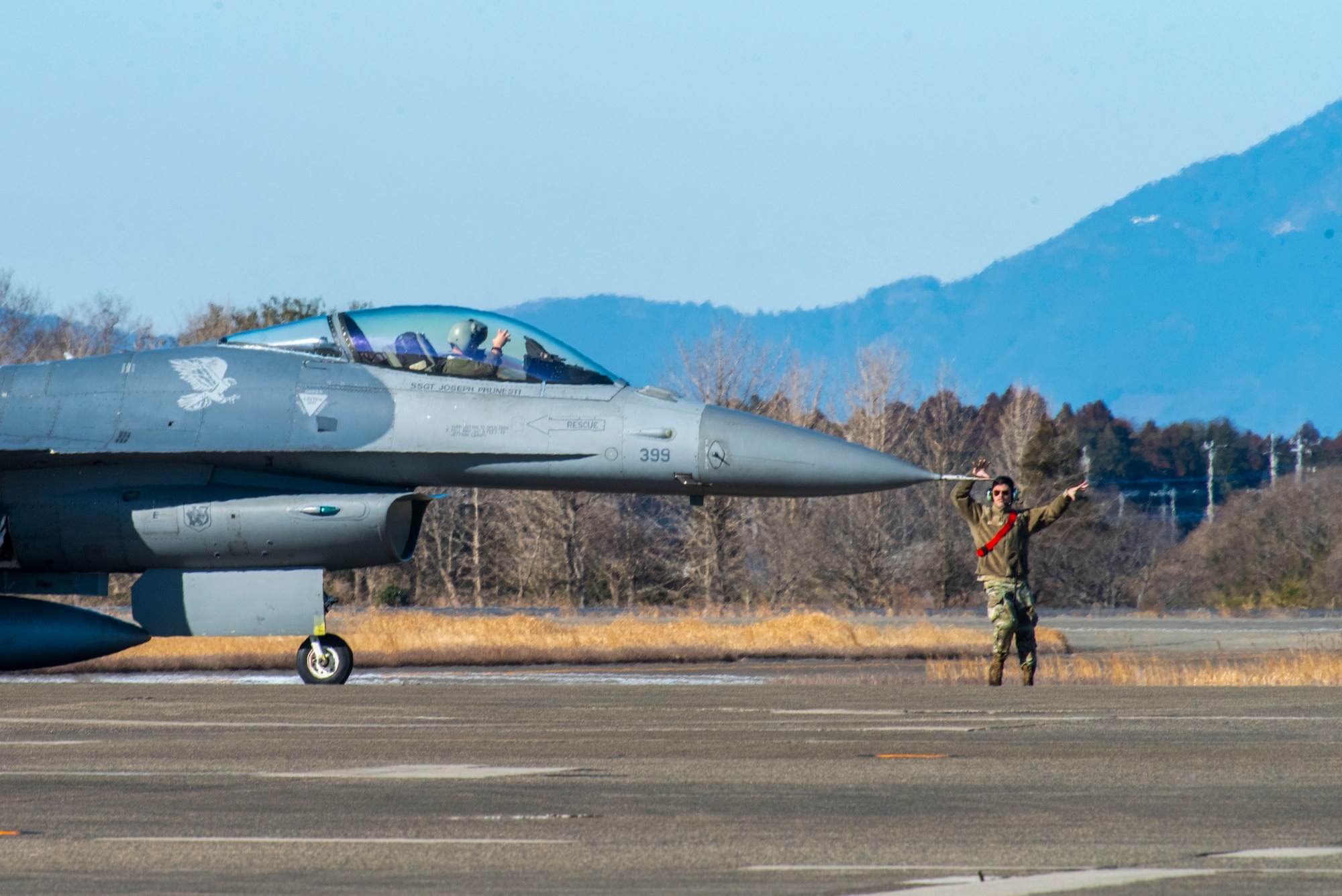 A U.S. Air Force Airman assigned to the 13th Fighter Generation Squadron marshals a U.S. Air Force F-16 Fighting Falcon during the first take-offs in support of the Aviation Training Relocation exercise at Hyakuri Air Base, Japan, Jan. 29, 2024.