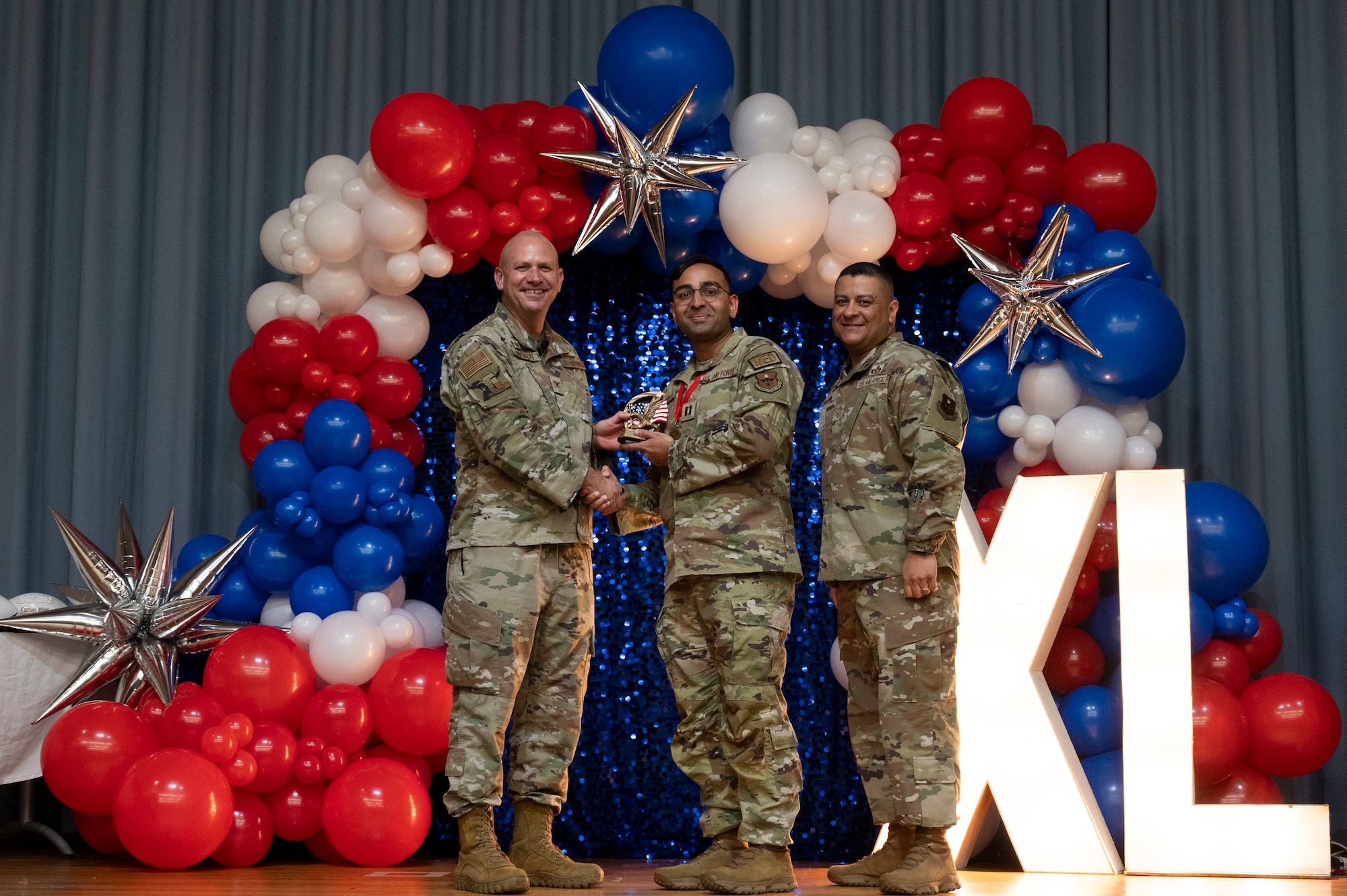 U.S. Air Force Col. Kevin Davidson, 47th Flying Training Wing (FTW) commander, and Chief Master Sgt. Lester Largaespada, 47th FTW command chief, present Capt. Baiwab Subedi, 47th Medical Group, an award during the 2023 47th FTW Annual Awards Ceremony at Laughlin Air Force Base, Texas, Feb. 2, 2024. Annual award winners were selected based on their technical expertise, demonstration of leadership and job performance. (U.S. Air Force photo by Senior Airman Kailee Reynolds)