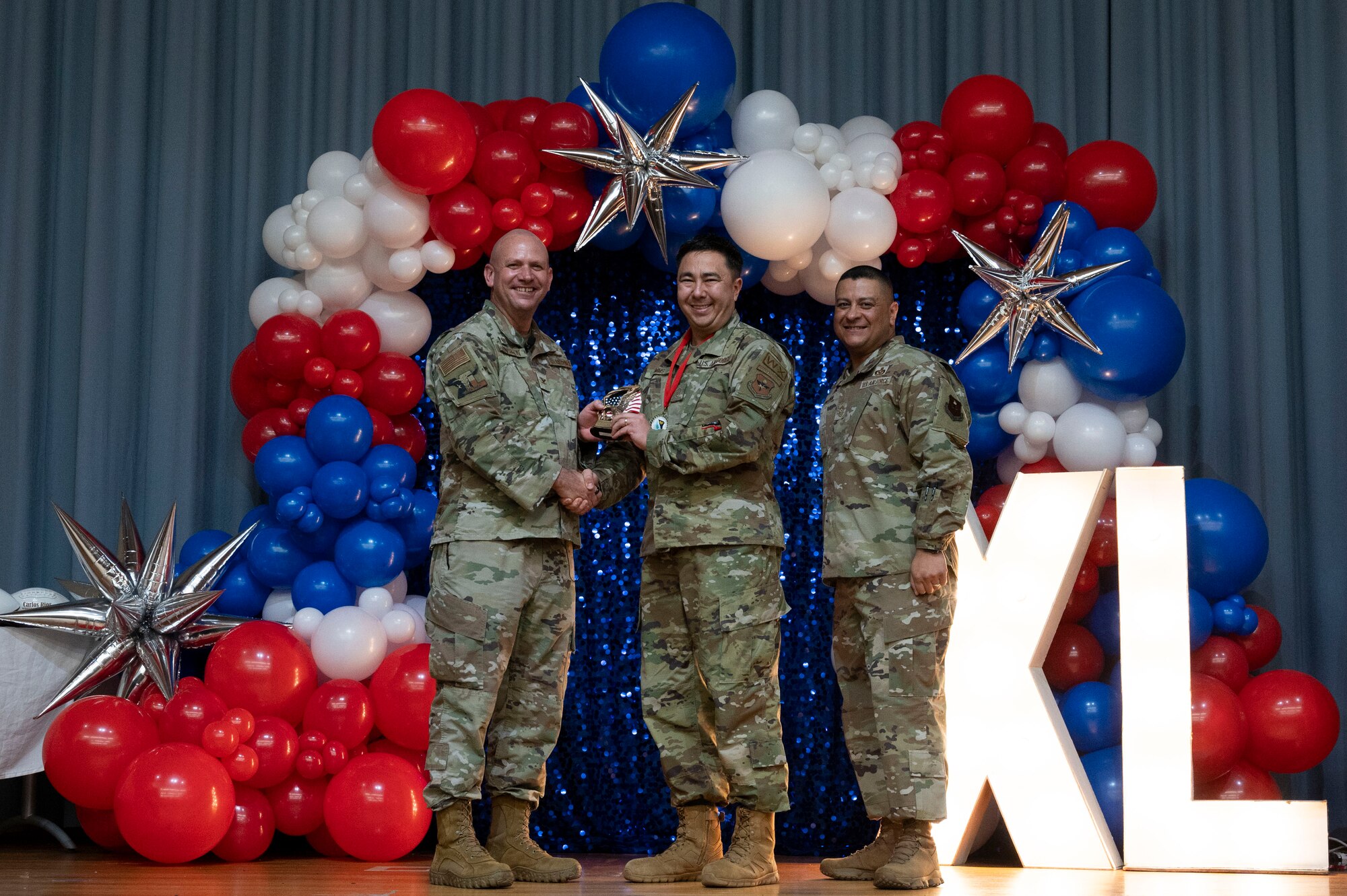 U.S. Air Force Col. Kevin Davidson, 47th Flying Training Wing (FTW) commander, and Chief Master Sgt. Lester Largaespada, 47th FTW command chief, present Master Sgt. Andrew Timms, 47th Operations Group, an award during the 2023 47th FTW Annual Awards Ceremony at Laughlin Air Force Base, Texas, Feb. 2, 2024. The annual awards recognized the top performers throughout the 47th Flying Training Wing during fiscal year 2023. (U.S. Air Force photo by Senior Airman Kailee Reynolds)