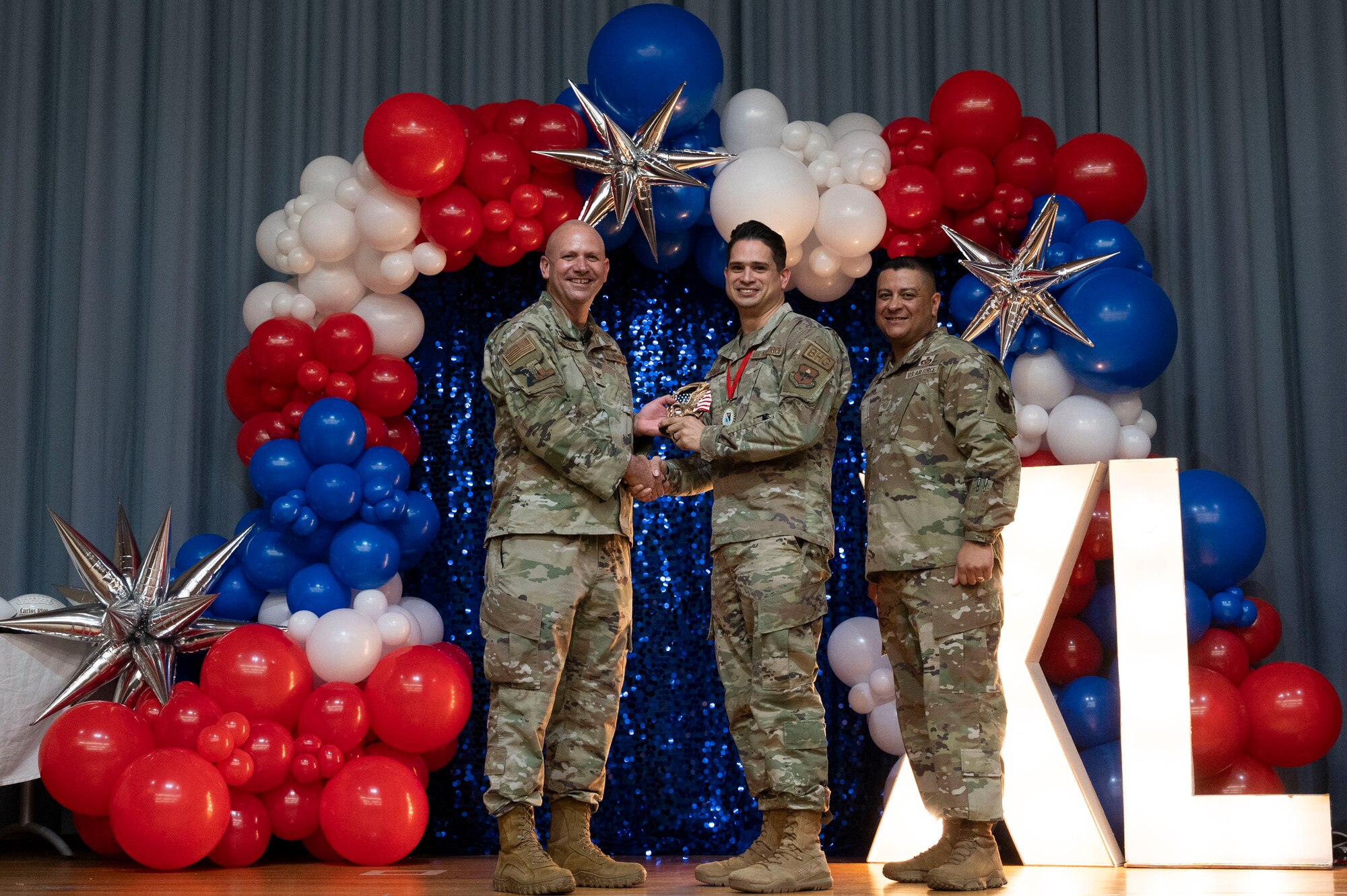 U.S. Air Force Col. Kevin Davidson, 47th Flying Training Wing (FTW) commander, and Chief Master Sgt. Lester Largaespada, 47th FTW command chief, present Tech. Sgt. Christian Ramos, 47th Mission Support Group, an award during the 2023 47th FTW Annual Awards Ceremony at Laughlin Air Force Base, Texas, Feb. 2, 2024. The annual awards recognized the top performers throughout the 47th Flying Training Wing during fiscal year 2023. (U.S. Air Force photo by Senior Airman Kailee Reynolds)