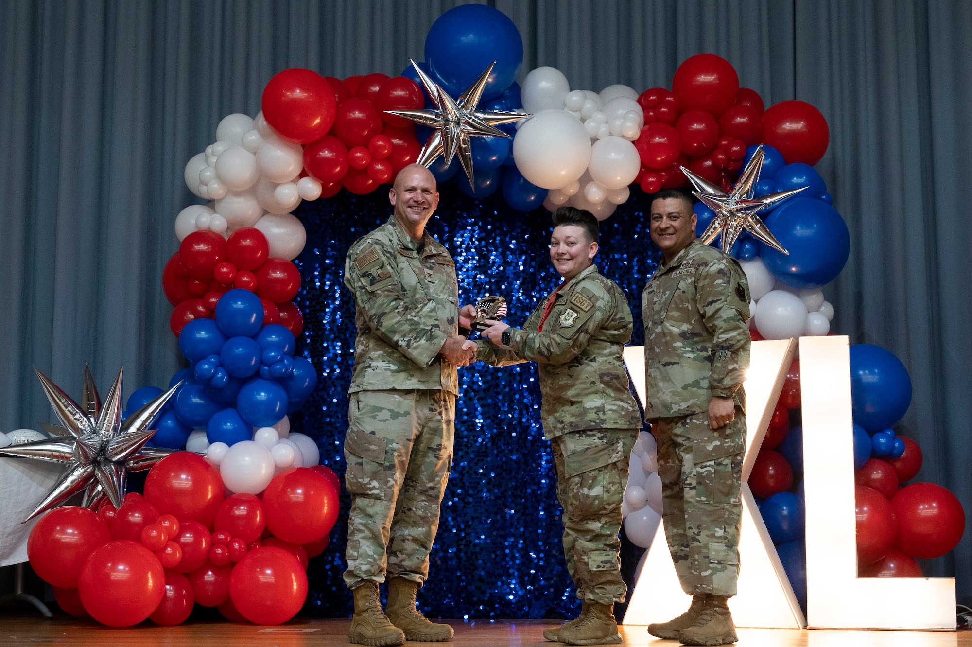 U.S. Air Force Col. Kevin Davidson, 47th Flying Training Wing (FTW) commander, and Chief Master Sgt. Lester Largaespada, 47th FTW command chief, present Master Sgt. Chelsea Moschell, 47th Operations Group, an award during the 2023 47th FTW Annual Awards Ceremony at Laughlin Air Force Base, Texas, Feb. 2, 2024. The annual awards recognized the top performers throughout the 47th Flying Training Wing during fiscal year 2023. (U.S. Air Force photo by Senior Airman Kailee Reynolds)