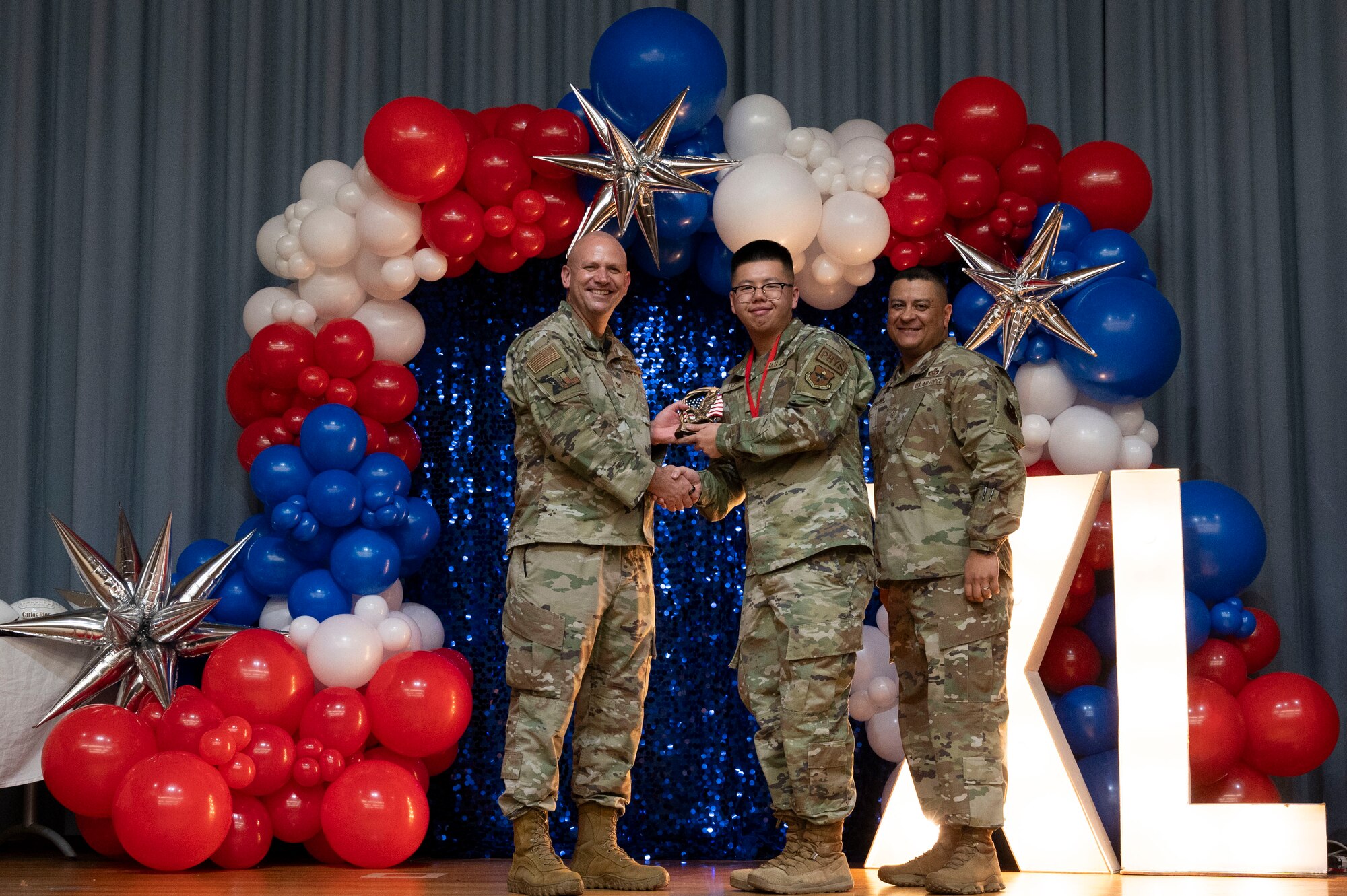 U.S. Air Force Col. Kevin Davidson, 47th Flying Training Wing (FTW) commander, and Chief Master Sgt. Lester Largaespada, 47th FTW command chief, present Airman 1st Class Alexander Lee, 47th Operations Group, an award during the 2023 47th FTW Annual Awards Ceremony at Laughlin Air Force Base, Texas, Feb. 2, 2024. The annual awards recognized the top performers throughout the 47th Flying Training Wing during fiscal year 2023. (U.S. Air Force photo by Senior Airman Kailee Reynolds)
