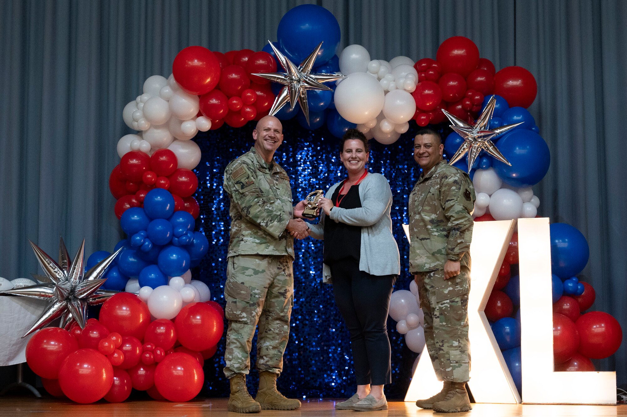 U.S. Air Force Col. Kevin Davidson, 47th Flying Training Wing (FTW) commander, and Chief Master Sgt. Lester Largaespada, 47th FTW command chief, present Laura Meyer-Frerich, 47th Mission Support Group, an award during the 2023 47th FTW Annual Awards Ceremony at Laughlin Air Force Base, Texas, Feb. 2, 2024. The annual awards recognized the top performers throughout the 47th Flying Training Wing during fiscal year 2023. (U.S. Air Force photo by Senior Airman Kailee Reynolds)