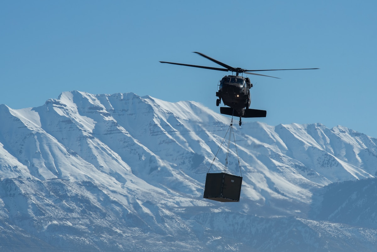Utah Army and Air National Guardsmen particpate in a joint Exercise involving a mobile kitchen being connected to a UH-60 Black Hawk on Jan. 31, 2024, at Camp Williams. Exercise Perses challenged the tactics, techniques and procedures of both Utah Air and Army National Guard units while testing innovative ideas and communication practices.
