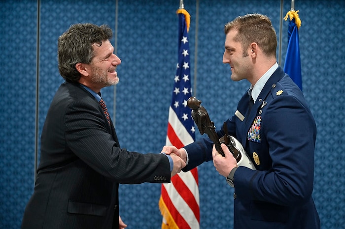 Kyle Anderson congratulates Maj. Brady Augustin after presenting him the 2022 Koren Kolligian, Jr. Trophy during a ceremony at the Pentagon, Arlington, Va., Feb. 7, 2024.