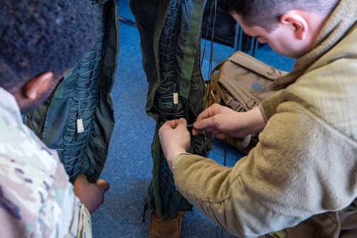 U.S. Air Force Airmen with the 13th Fighter Generation Squadron lace up a pilot’s G-suit during the Aviation Training Relocation exercise at Hyakuri Air Base, Japan, Jan. 29, 2024.