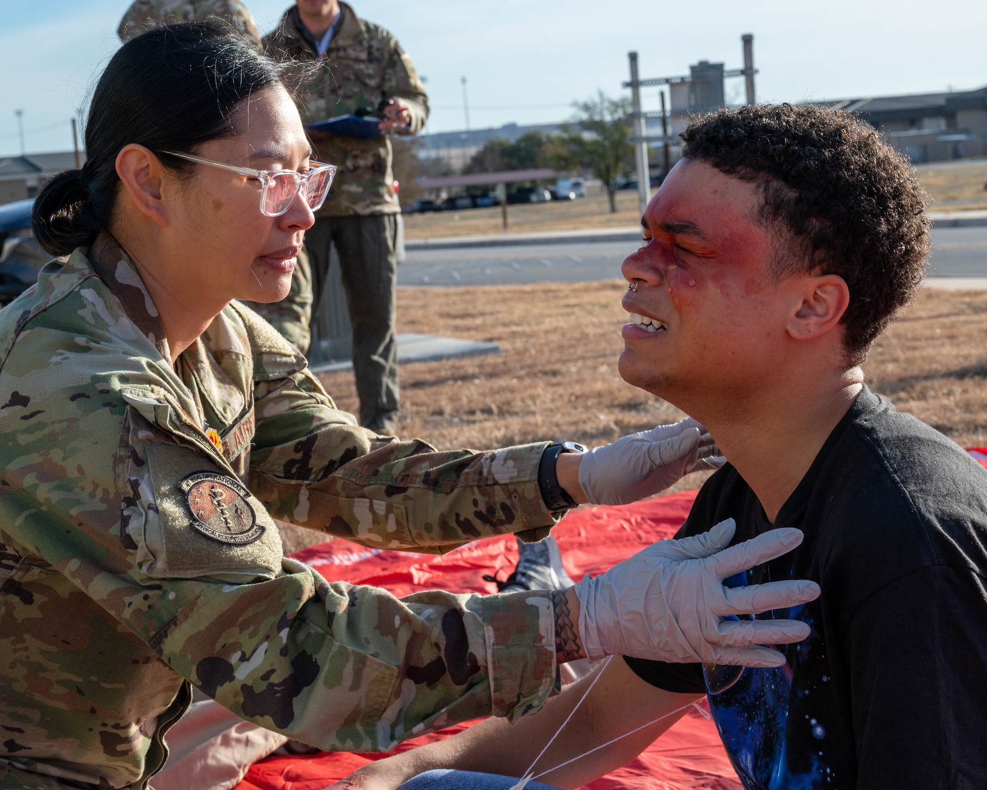 U.S. Air Force Tech. Sgt. Jasmine Pabalan, 47th Operational Medical Readiness Squadron flight medicine chief, checks the simulated injuries of an Airman during exercise Ready Eagle II at Laughlin Air Force Base, Texas, Jan. 31, 2024. Exercise Ready Eagle II allowed Airmen to sharpen their response procedures, patient care skills, and increase service member survivability. Airmen practiced responding to an explosion, treating trauma and chemical burns. (U.S. Air Force photo by Staff Sgt. Nicholas Larsen)