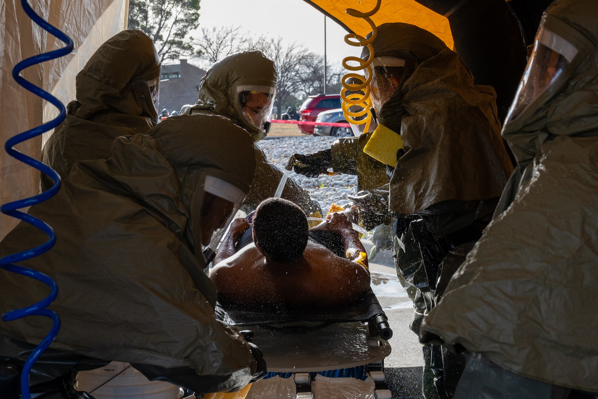 U.S. Air Force Airmen from the 47th Medical Group (MDG) decontaminate a patient during exercise Ready Eagle II at Laughlin Air Force Base, Texas, Jan. 31, 2024.  Exercise Ready Eagle II allowed Airmen to sharpen their response procedures, patient care skills, and increase service member survivability. Decontamination allows Airmen to clean off chemicals before moving them into the 47th MDG building for further treatment. (U.S. Air Force photo by Staff Sgt. Nicholas Larsen)