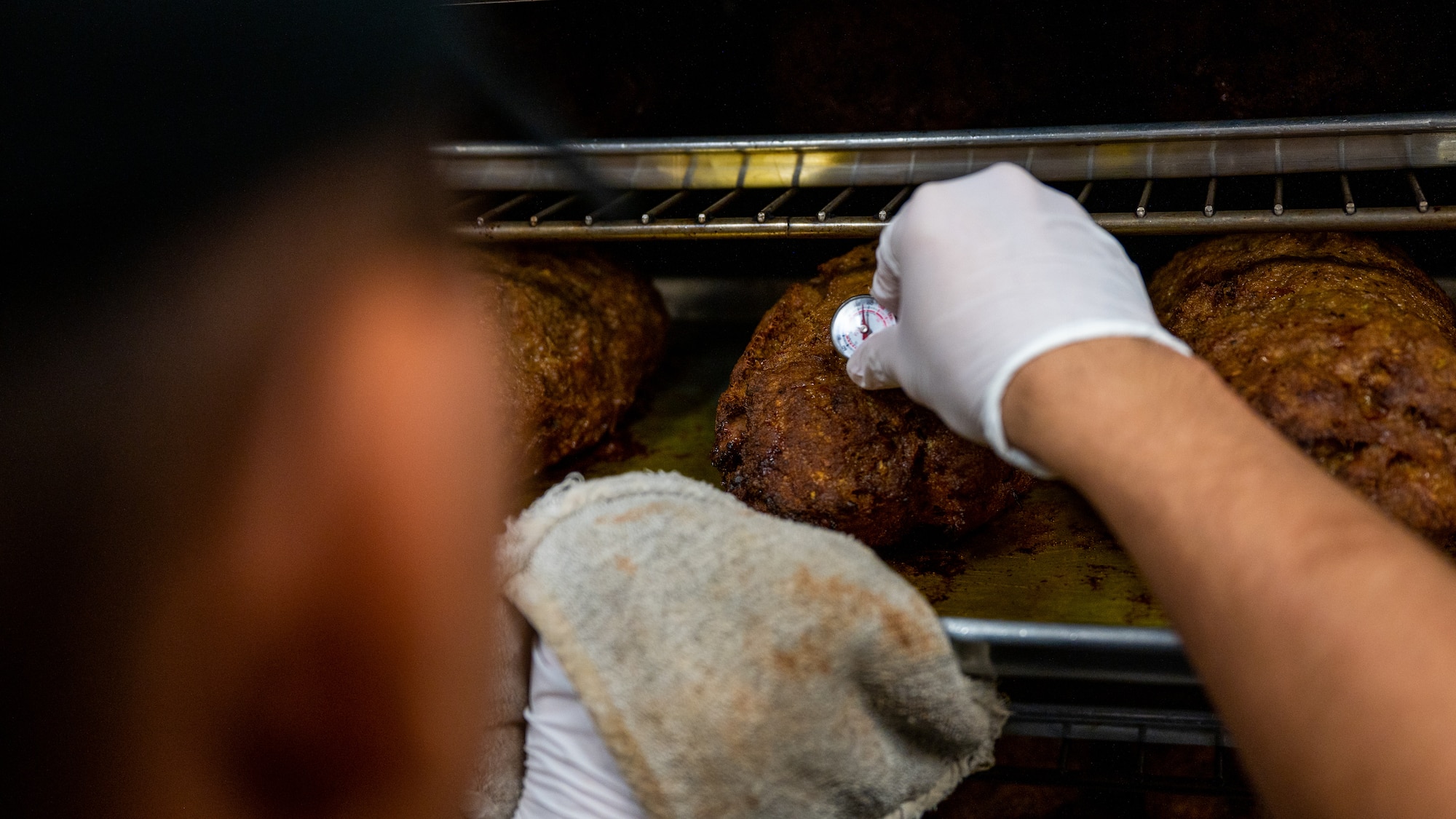 Staff Sgt. Huy Huynh checks on the temperature of food while preparing for lunch.