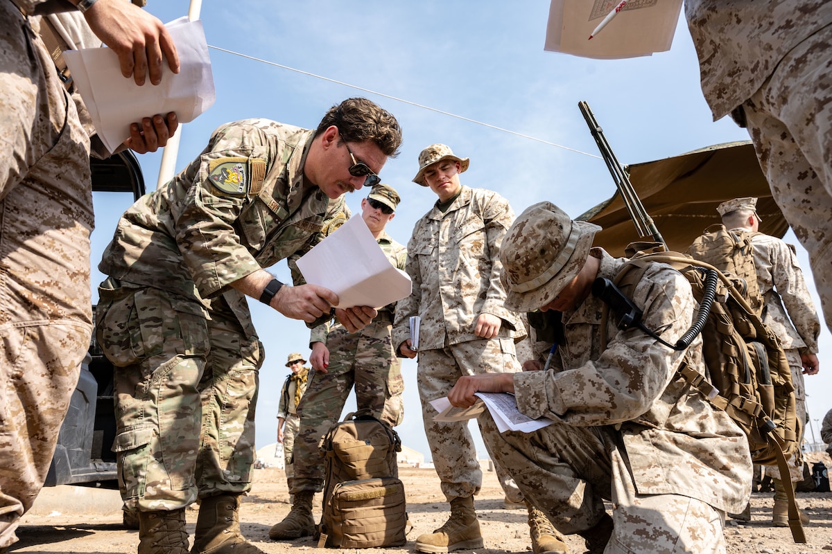 Service members discuss coordinates during a training exercise.