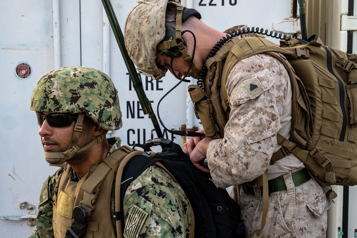 U.S. Marine and Navy service members check their communications equipment.