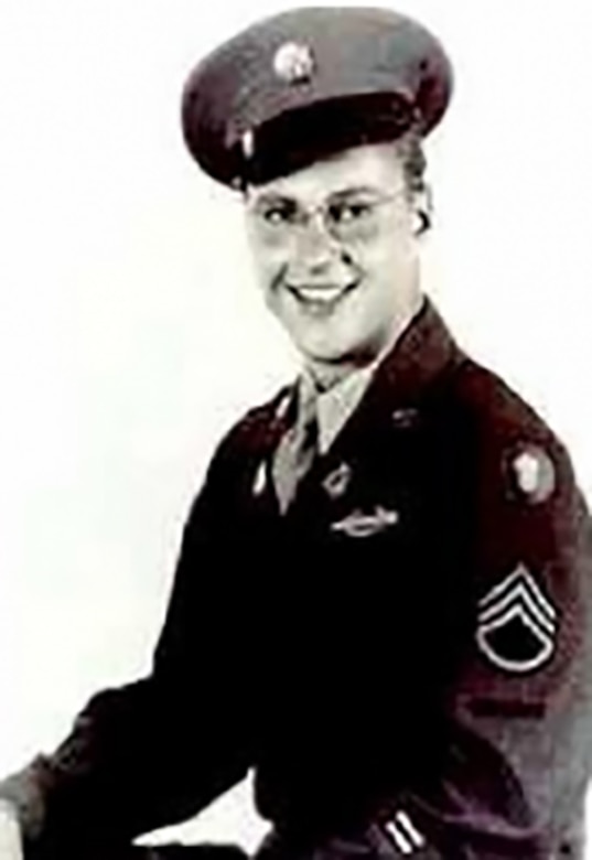 A black and white photo of a smiling uniformed service member.