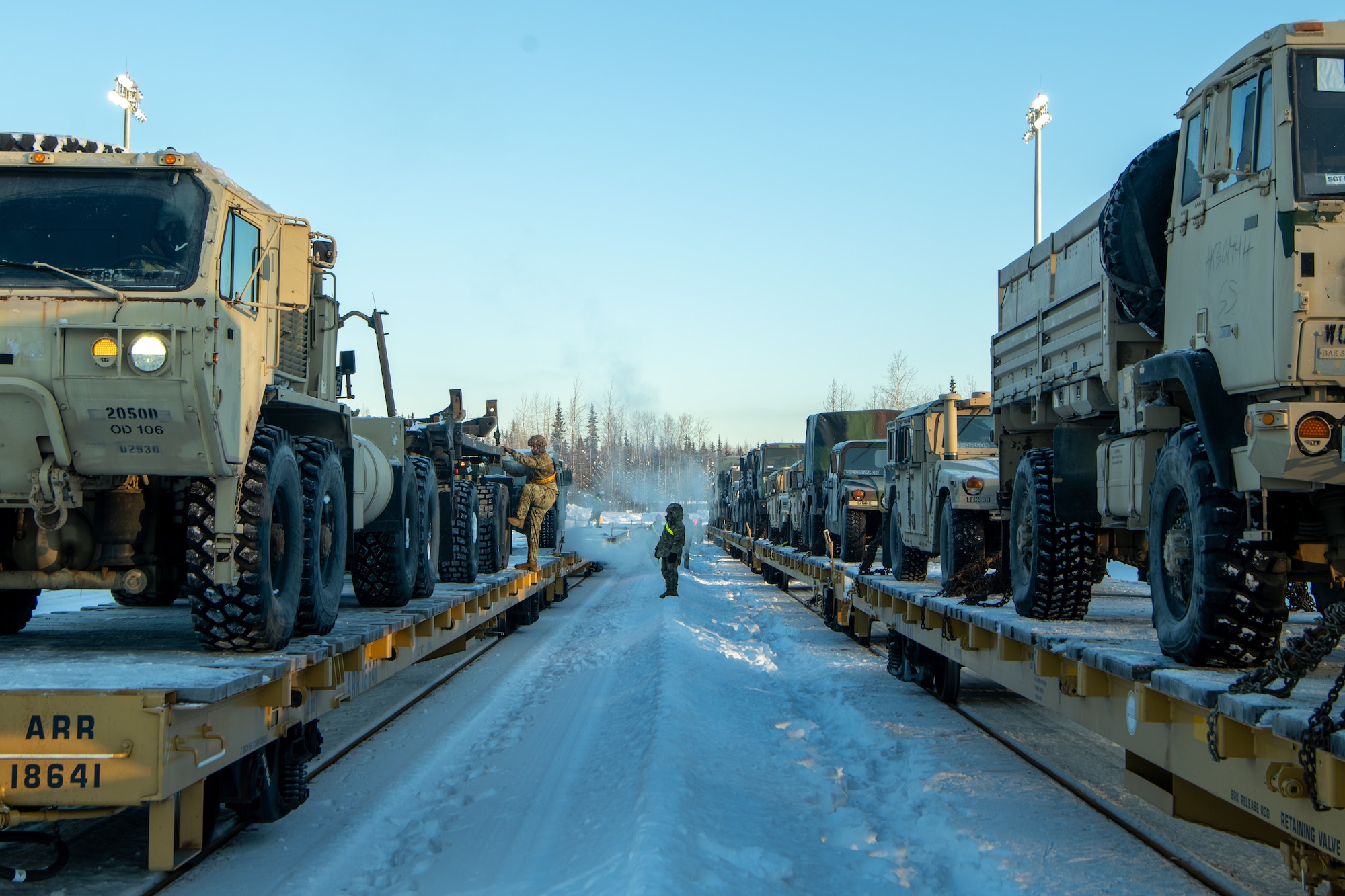 U.S. Army Soldiers assigned to the 17th Combat Support Sustainment Battalion and members of the U.S. Air Force's 773rd Logistics Readiness Squadron load vehicles onto rail lines at Joint Base Elmendorf Richardson, Alaska, Jan. 22, 2024, ahead of Joint Pacific Multinational Readiness Center 24-2.