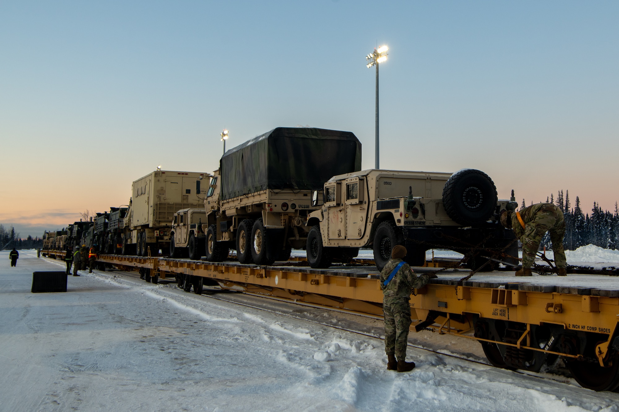 U.S. Army Soldiers assigned to the 17th Combat Support Sustainment Battalion and members of the U.S. Air Force's 773rd Logistics Readiness Squadron load vehicles onto rail lines at Joint Base Elmendorf Richardson, Alaska, Jan. 22, 2024, ahead of Joint Pacific Multinational Readiness Center 24-2.