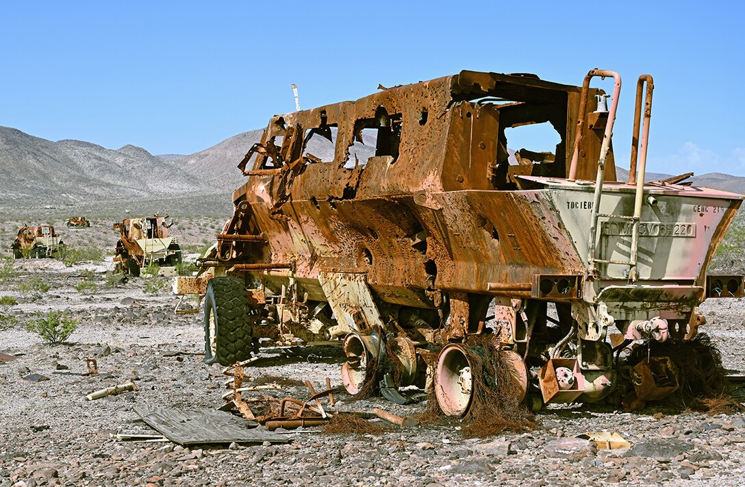 MRAPS devastated by artillery fire stretch to the horizon in the desert.