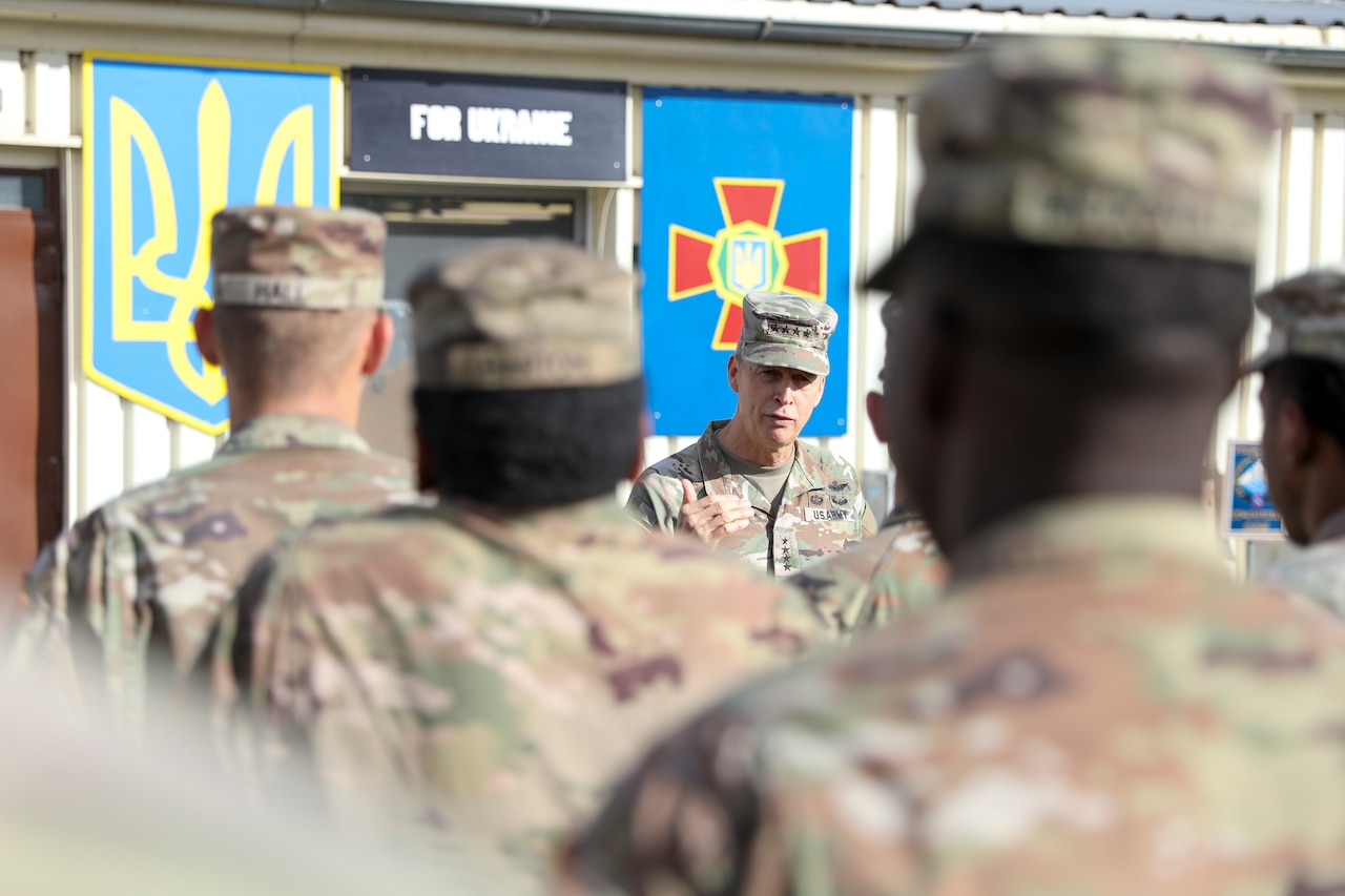 A man in uniform addresses service members in formation.
