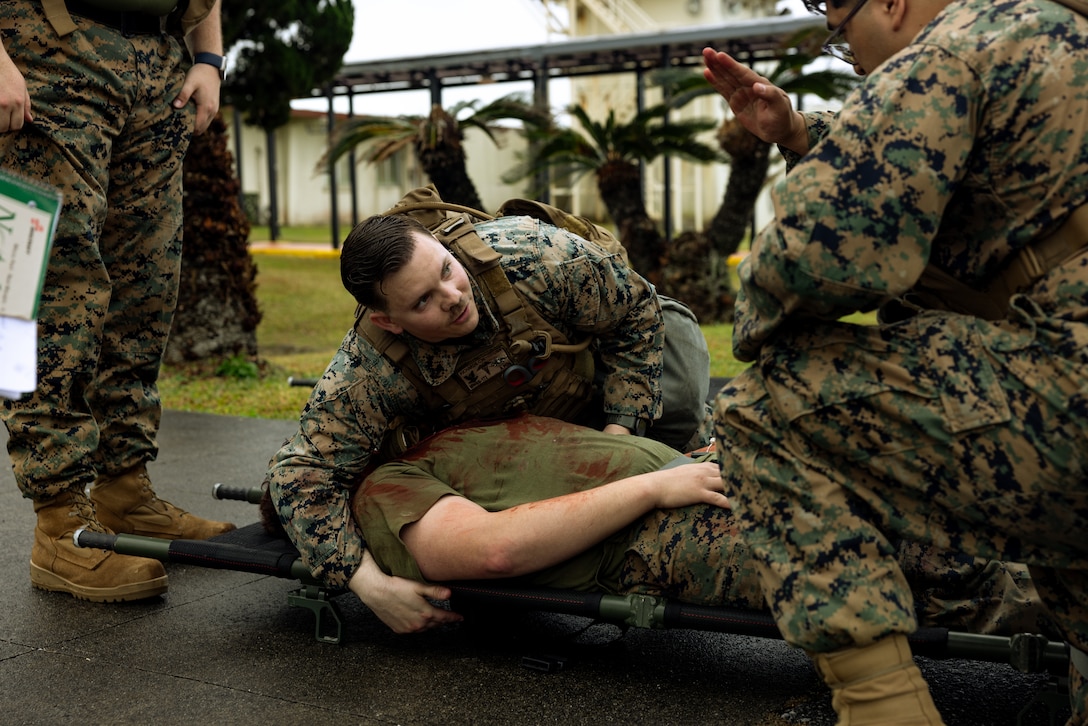U.S. Navy hospital corpsmen with Marine Wing Support Squadron 172, 1st Marine Aircraft Wing, tend to a simulated victim during a Base Recovery After Attack and Airfield Damage Repair training exercise on Marine Corps Air Station Futenma, Feb. 4, 2024. This training event simulated how the joint-force would operate in the event of a foreign attack on U.S. military-owned airfields in Okinawa. MWSS-172 employed the use of explosive ordnance disposal, engineer, maintenance, and communication teams within their squadron for damage assessment and recovery. (U.S. Marine Corps photo by Cpl. Thomas Sheng)