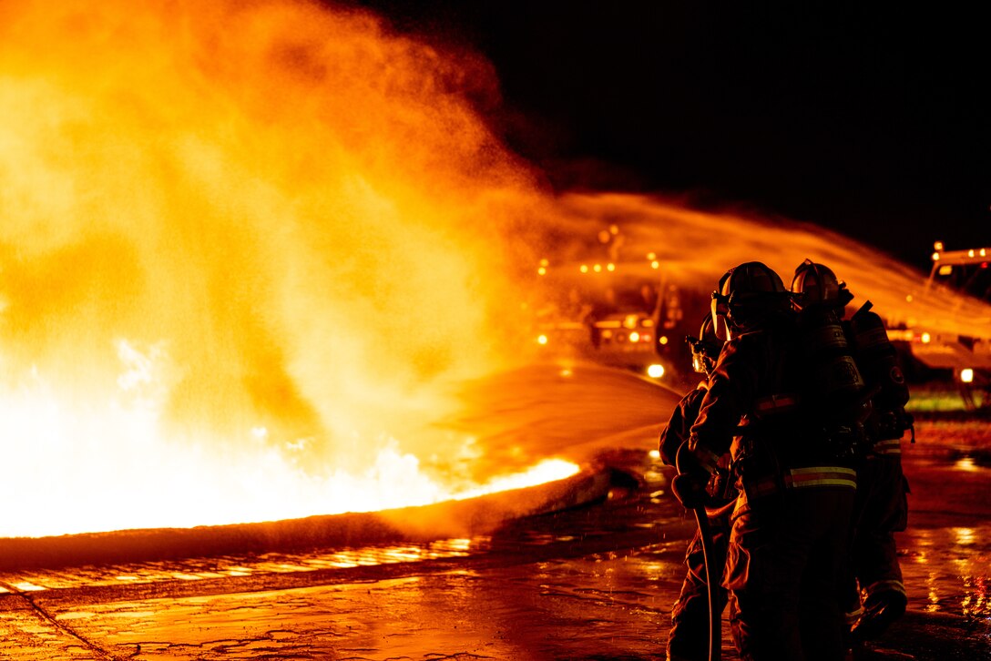 U.S. Marines with Marine Wing Support Squadron 172, 1st Marine Aircraft Wing, extinguish a fire during a live fire training exercise on Marine Corps Air Station Futenma, Feb. 4, 2024. This training is organized quarterly for Marine firefighters to respond to real life firefighting scenarios. MWSS-172 was accompanied by Crash Fire Rescue Marines with Headquarters and Headquarters Support Squadron and bulk fuel specialists. (U.S. Marine Corps photo by Cpl. Thomas Sheng)