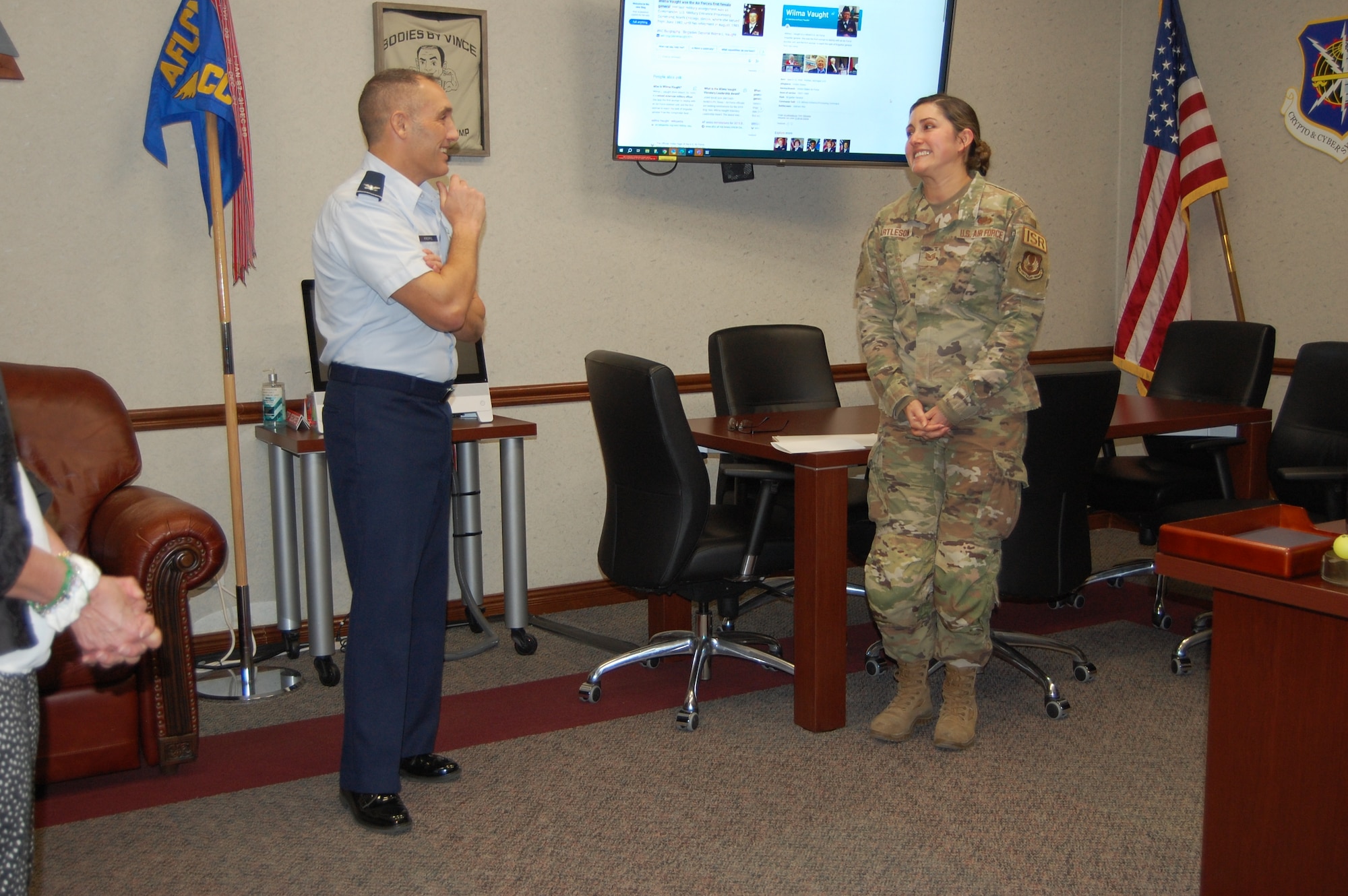 Two Air Force airmen looking at each other and laughing.