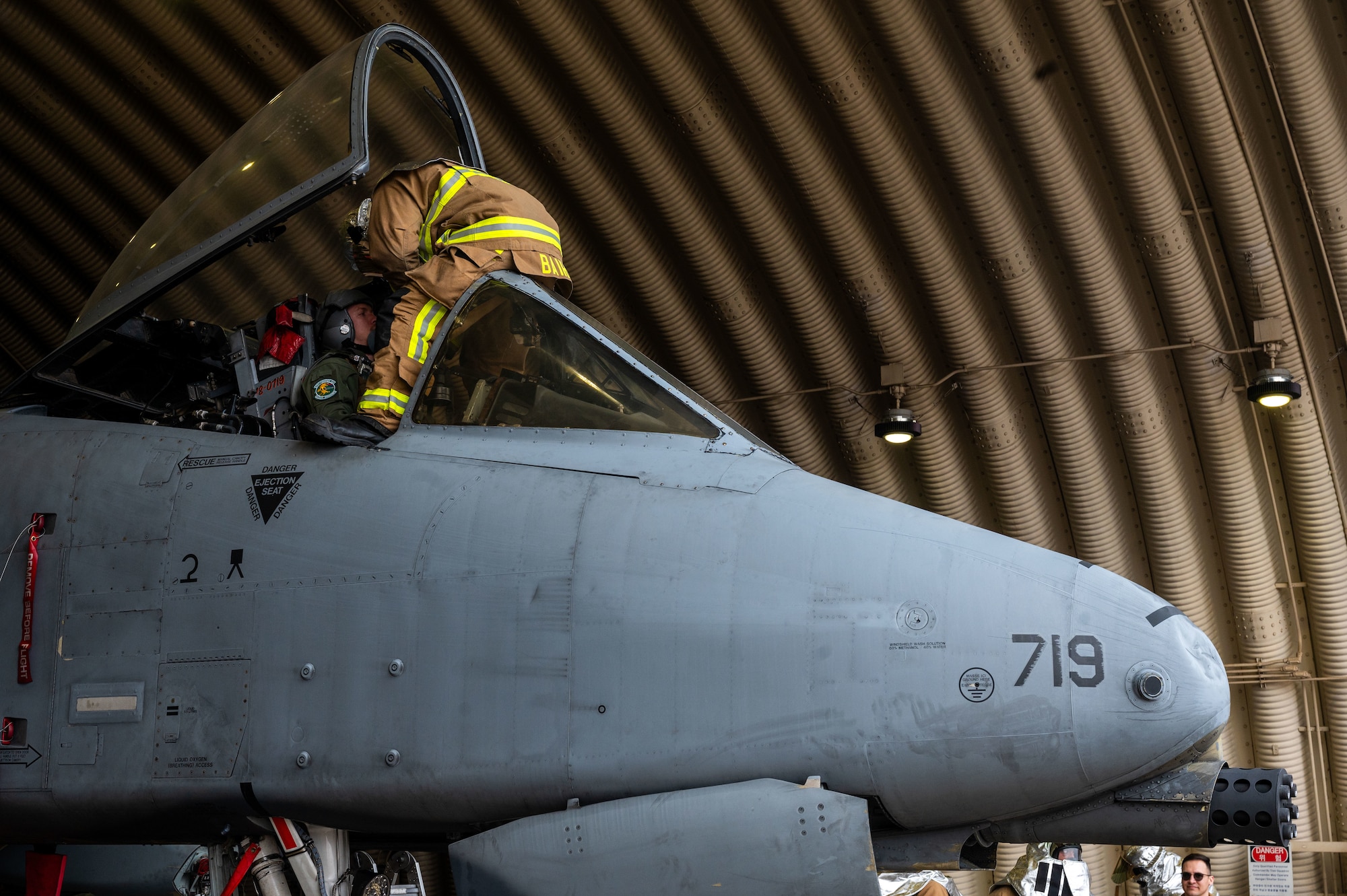 U.S. Air Force Senior Airman Jeremiah Baird, 51st Civil Engineer Squadron firefighter, removes an A-10C Thunderbolt II pilot from the cockpit due to a simulated flight line emergency at Osan Air Base, Republic of Korea, Feb. 1, 2024. Firefighters from the 51st CES continuously train in order to maintain the level of readiness needed to ensure safety for base personnel. (U.S. Air Force photo by Airman 1st Class Chase Verzaal)